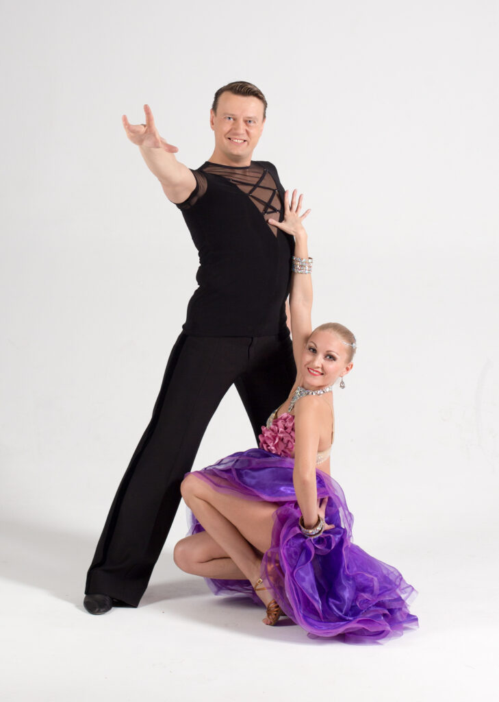 Ballroom dance couple performing energetic quickstep routine at Dance Cult Studio