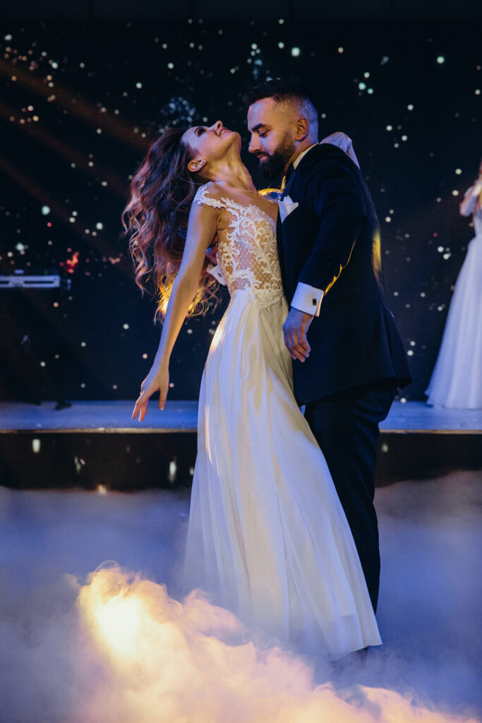 Engaged couple practicing first dance in a supportive studio environment